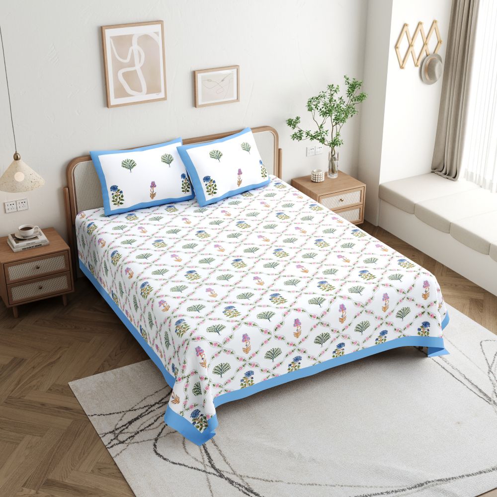 An image showing Somyariti 100% Cotton Queen Bedsheet Set with Hand Block Print draped on a bed in a spacious and well lit bedroom.